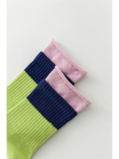 Close-up of the green sock's pink rolled edge and navy ribbed band
