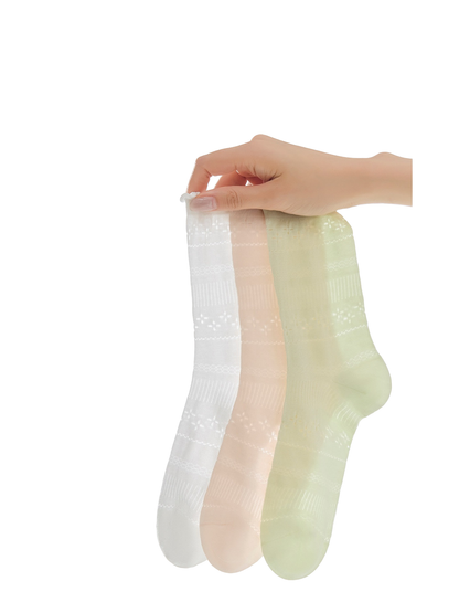 White, blush and light green pointelle crew socks displayed together