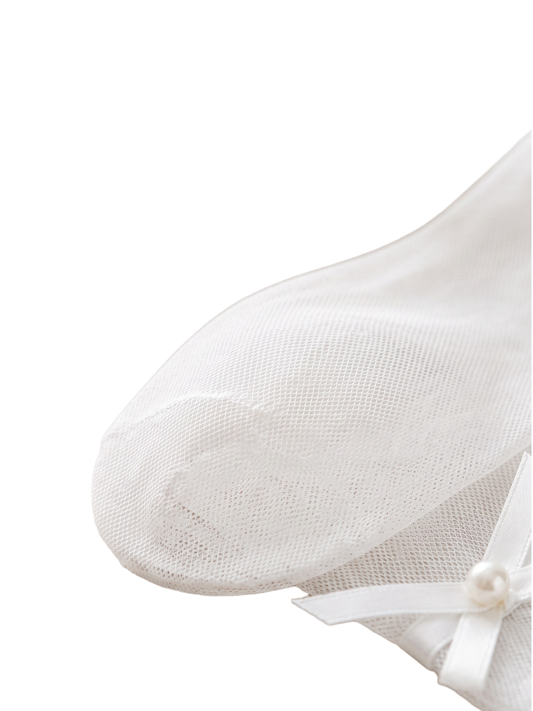 Close-up of the fine white mesh texture and pearl-centered ribbon bow