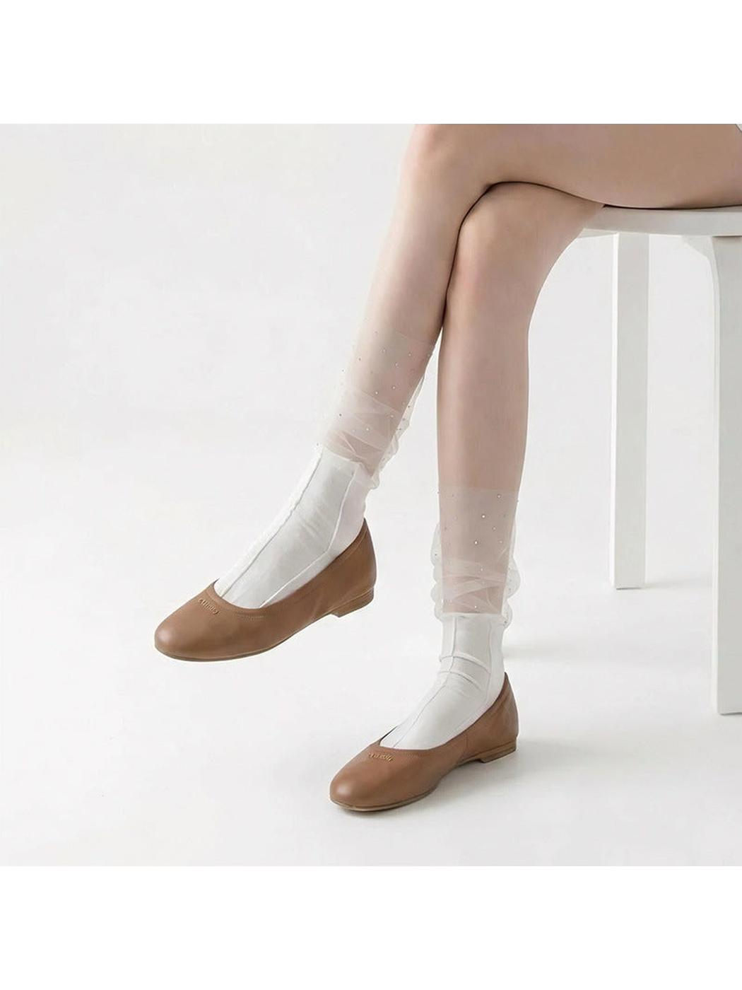 White sheer ruffle crew socks with sparkling dots, worn with brown flats