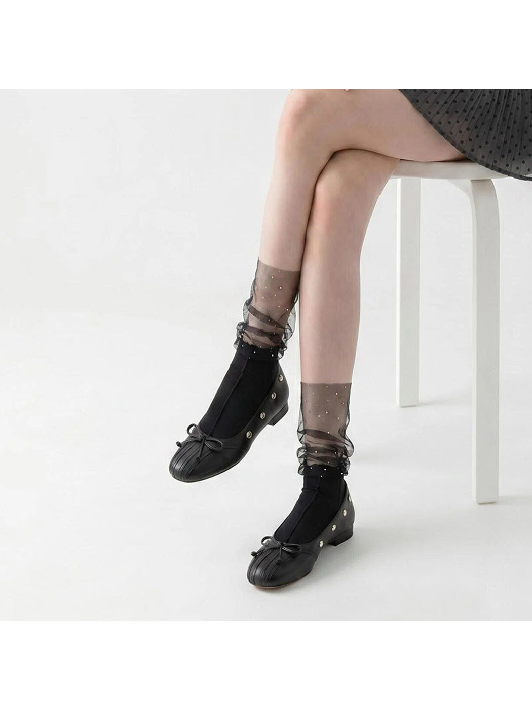 Black sheer ruffle crew socks with sparkling dots, worn with black flats