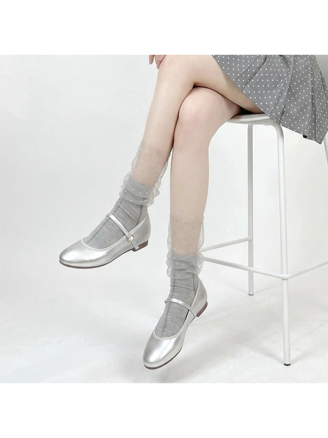 Gray sheer ruffle crew socks with sparkling dots, worn with silver flats