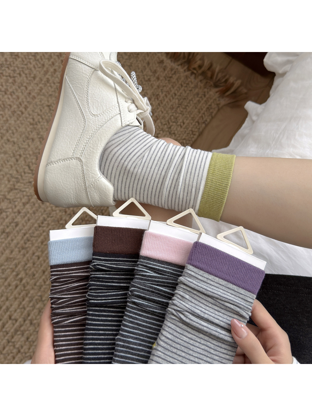 White striped crew sock worn with a white sneaker beside four color options