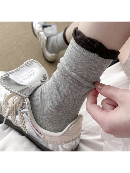 Light gray ruffle-cuff sock worn with a silver sneaker