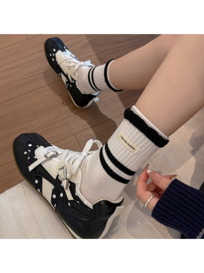 White striped crew socks worn with black-and-white sneakers