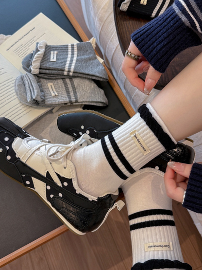 Close-up of white striped crew socks with contrasting ruffled cuffs and labels