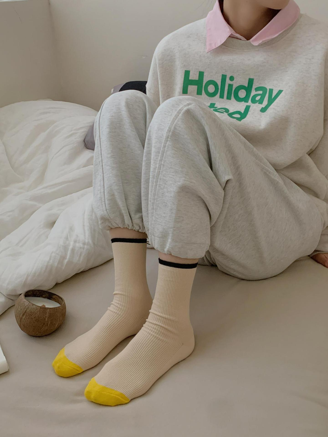 Cream ribbed crew socks with yellow toes and black cuff trim, front worn view