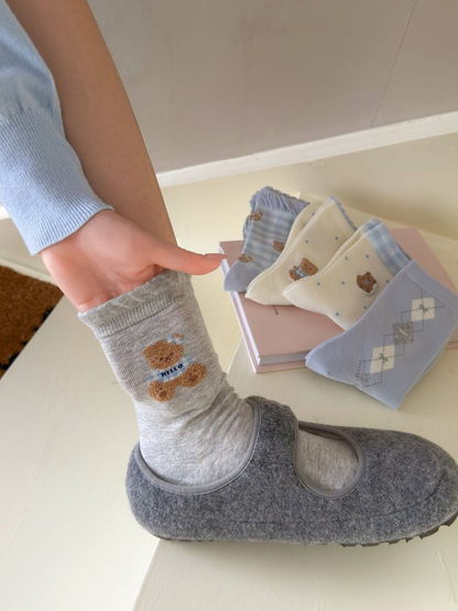 Heather gray teddy bear crew sock worn beside four folded designs