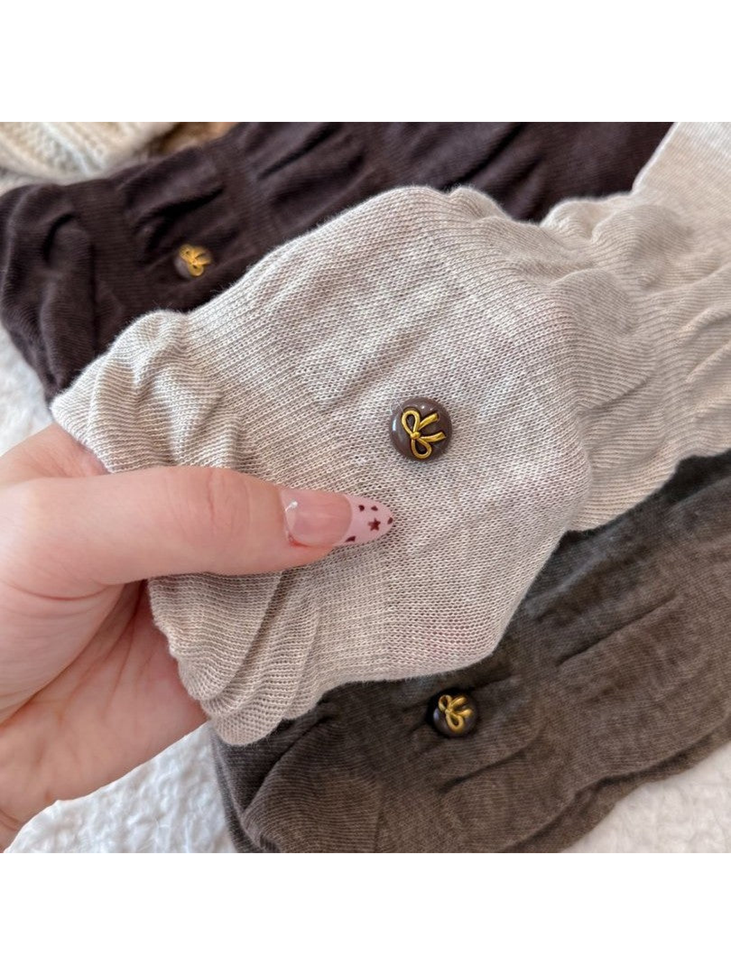 Close-up of gathered sock texture and gold-tone bow buttons
