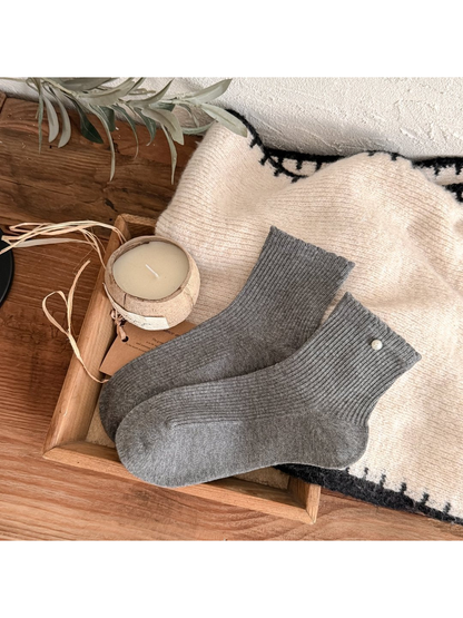 Dark gray ribbed crew socks with a pearl-like cuff bead