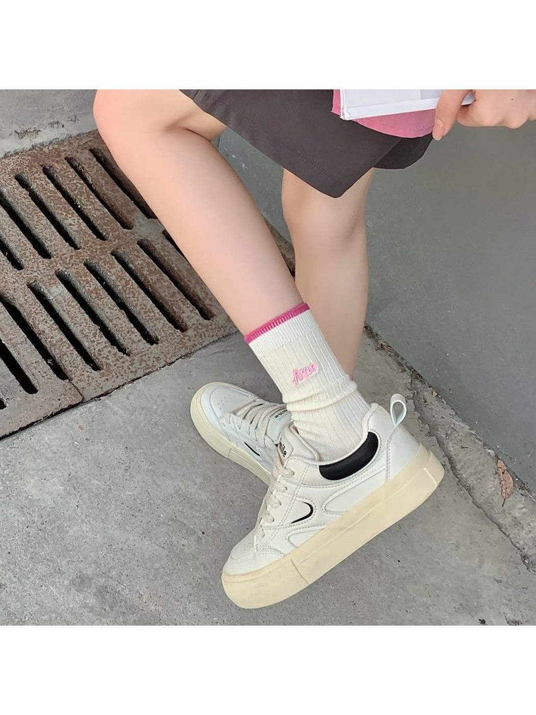 Ivory ribbed crew socks with pink cuffs worn with white sneakers