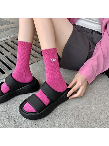 Pink ribbed crew socks worn with black open-toe sandals