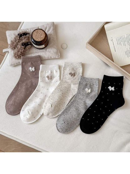 Five color variations of dotted crew socks with raised dog motifs
