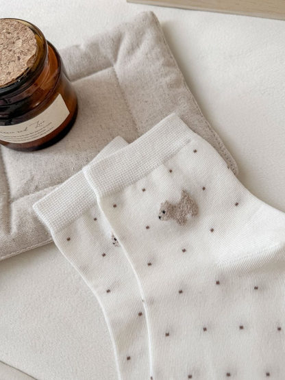 Close-up of the ribbed cuffs and raised dog appliques on white dotted socks