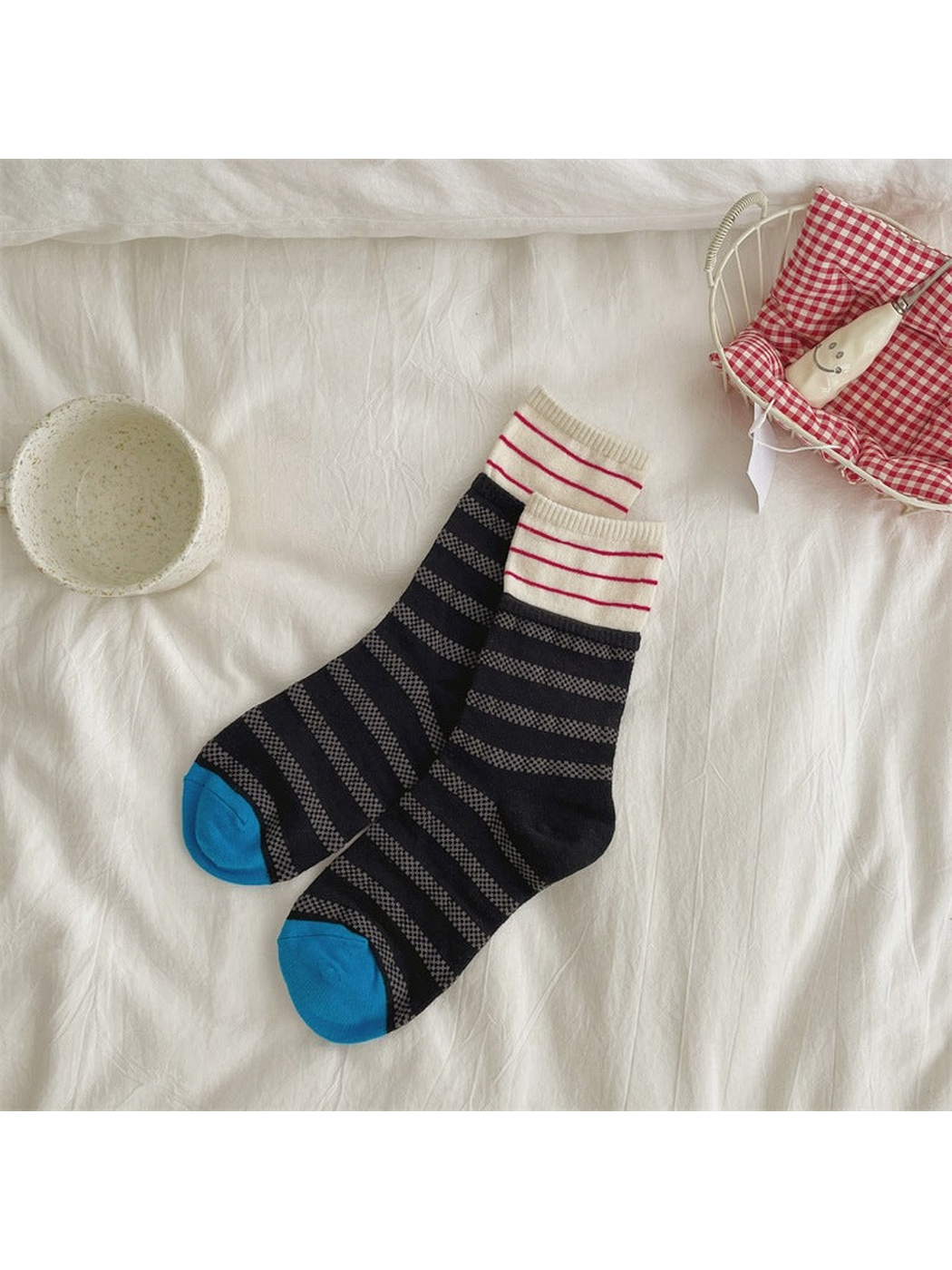 Black and gray striped crew socks with cream cuffs and blue toes