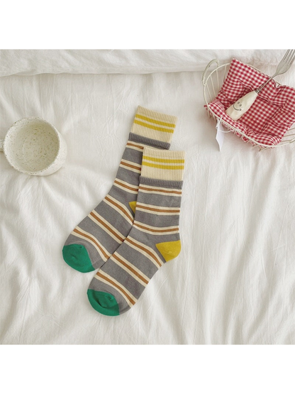 Gray striped crew socks with ivory cuffs and green toes