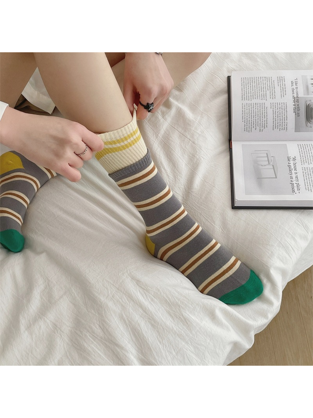 Gray striped crew socks worn in a seated side view