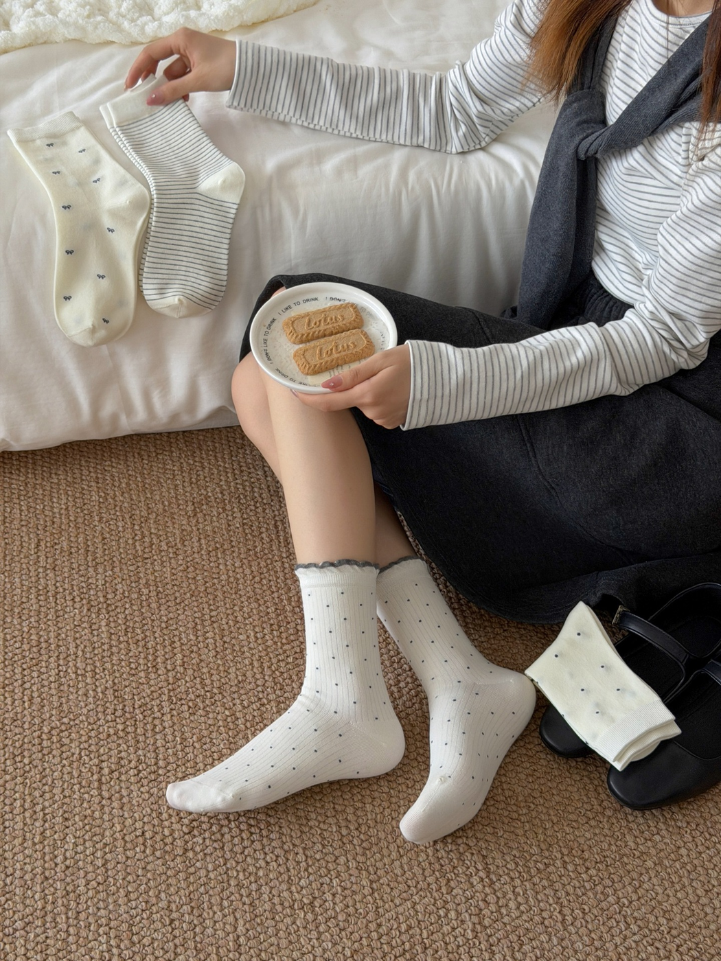 Ivory ruffled polka-dot crew socks worn beside displayed bow and striped styles
