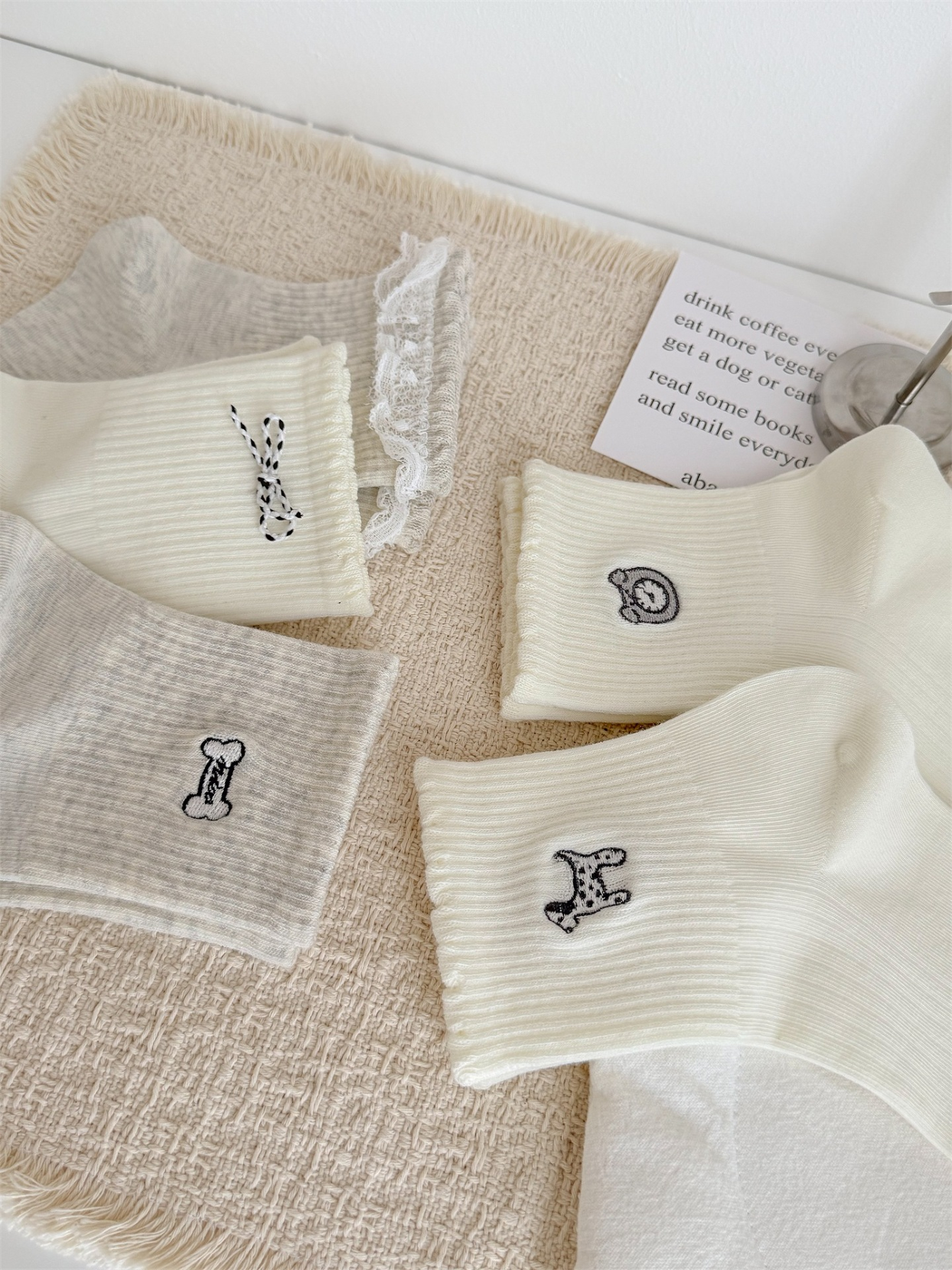 Close-up of ribbed cuffs with bow, lace, clock, dog and bone details