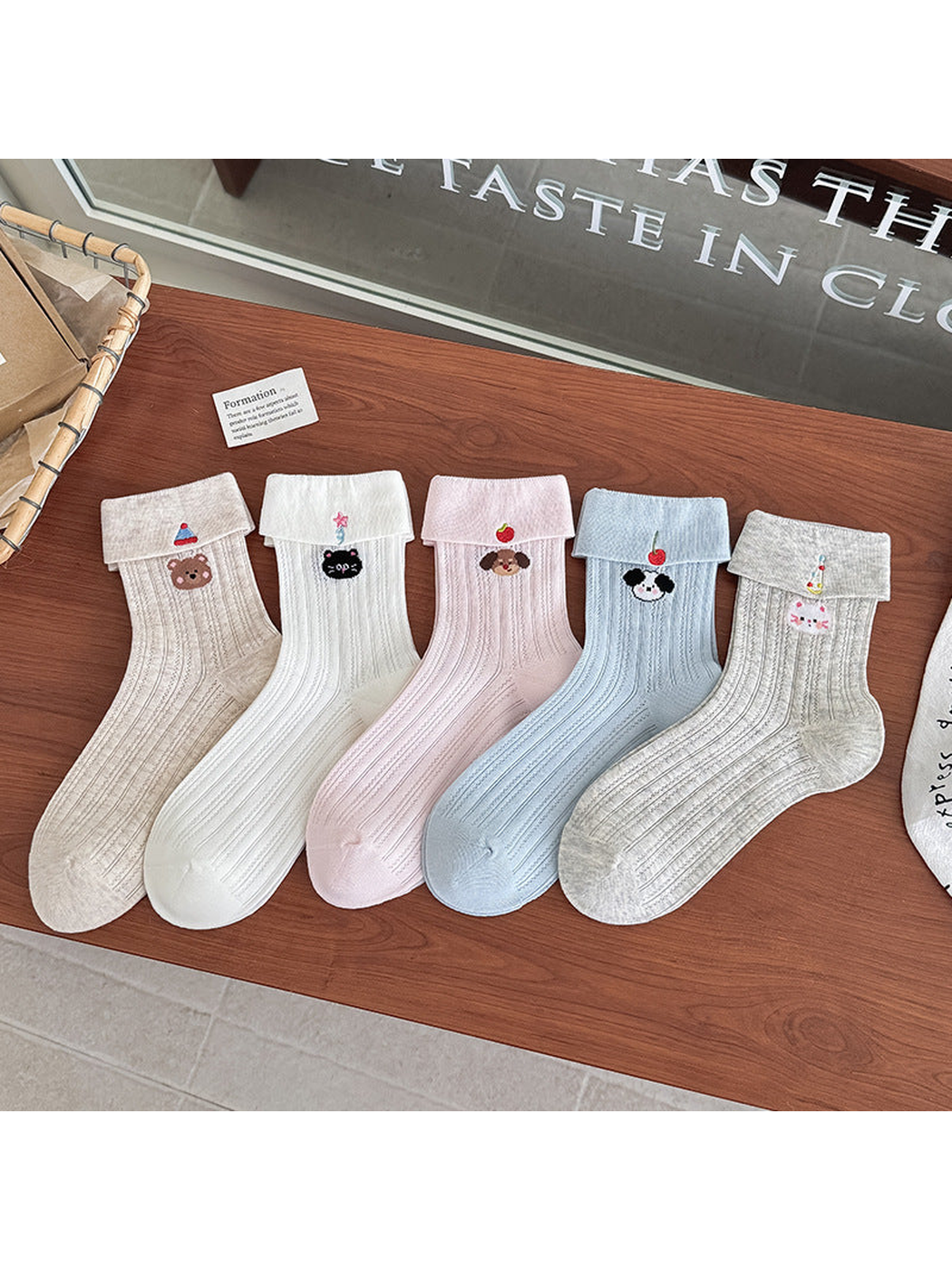 Five embroidered crew sock colors arranged side by side on a wooden table
