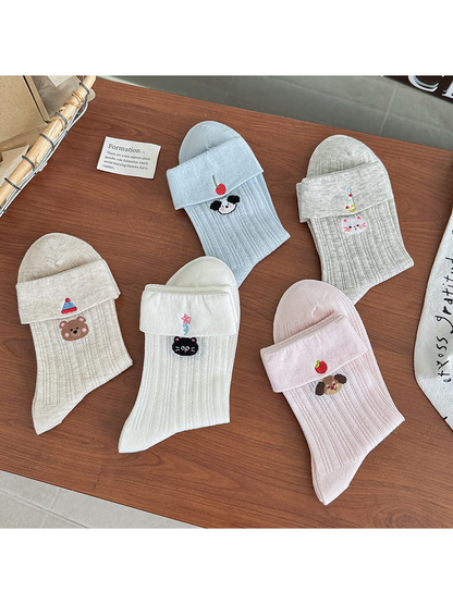 Five embroidered crew sock styles displayed with folded cuffs