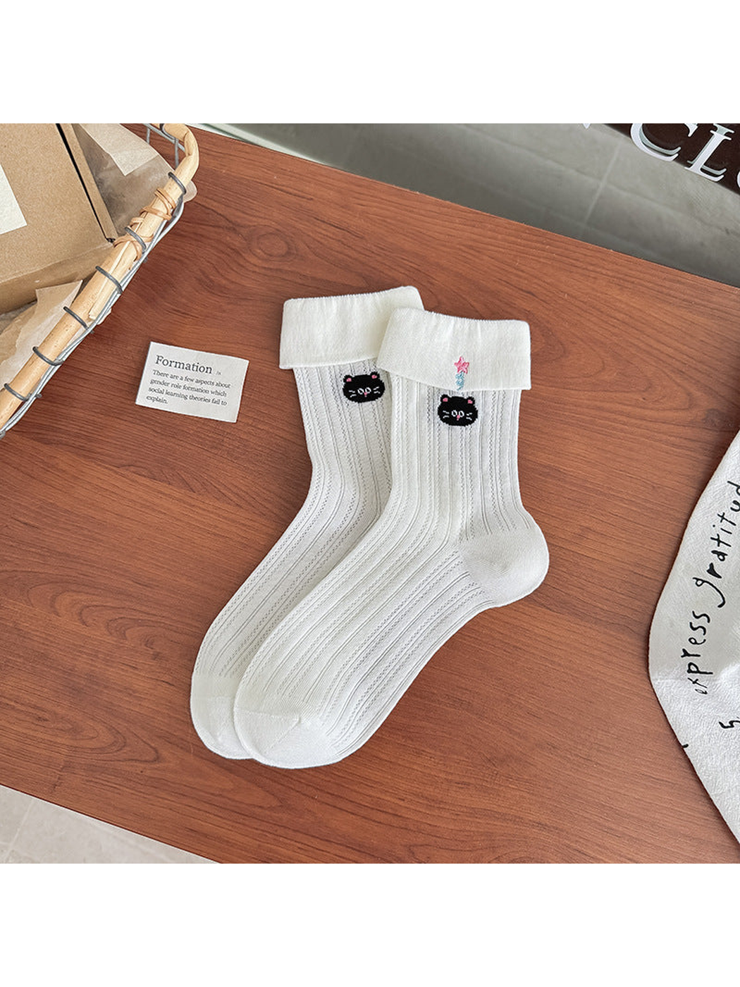 Ivory pointelle crew socks with folded cuffs and black cat embroidery