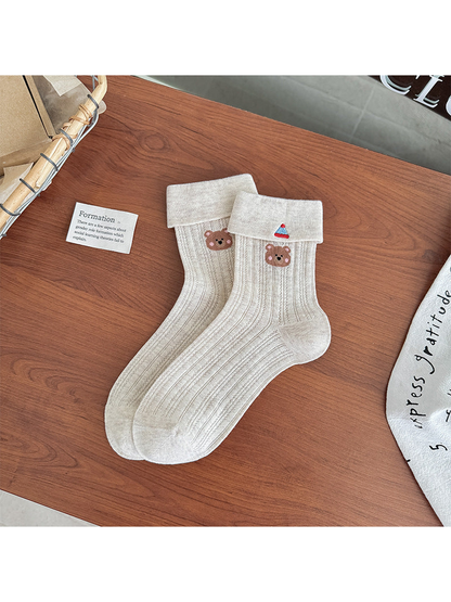 Beige pointelle crew socks with folded cuffs and bear embroidery