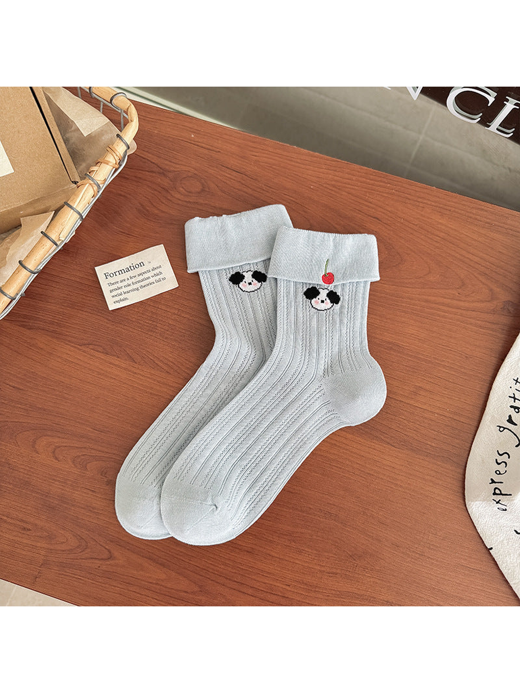 Light blue pointelle crew socks with folded cuffs and panda embroidery