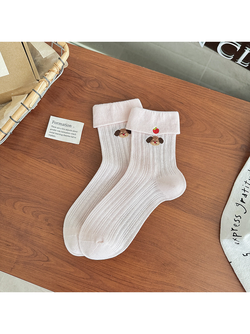 Light pink pointelle crew socks with folded cuffs and dog embroidery