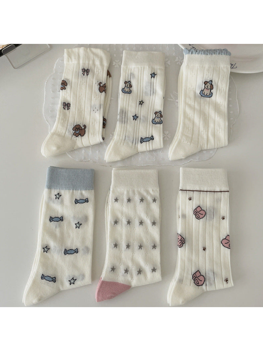 Six ivory crew sock styles with dog, candy, star and slipper motifs