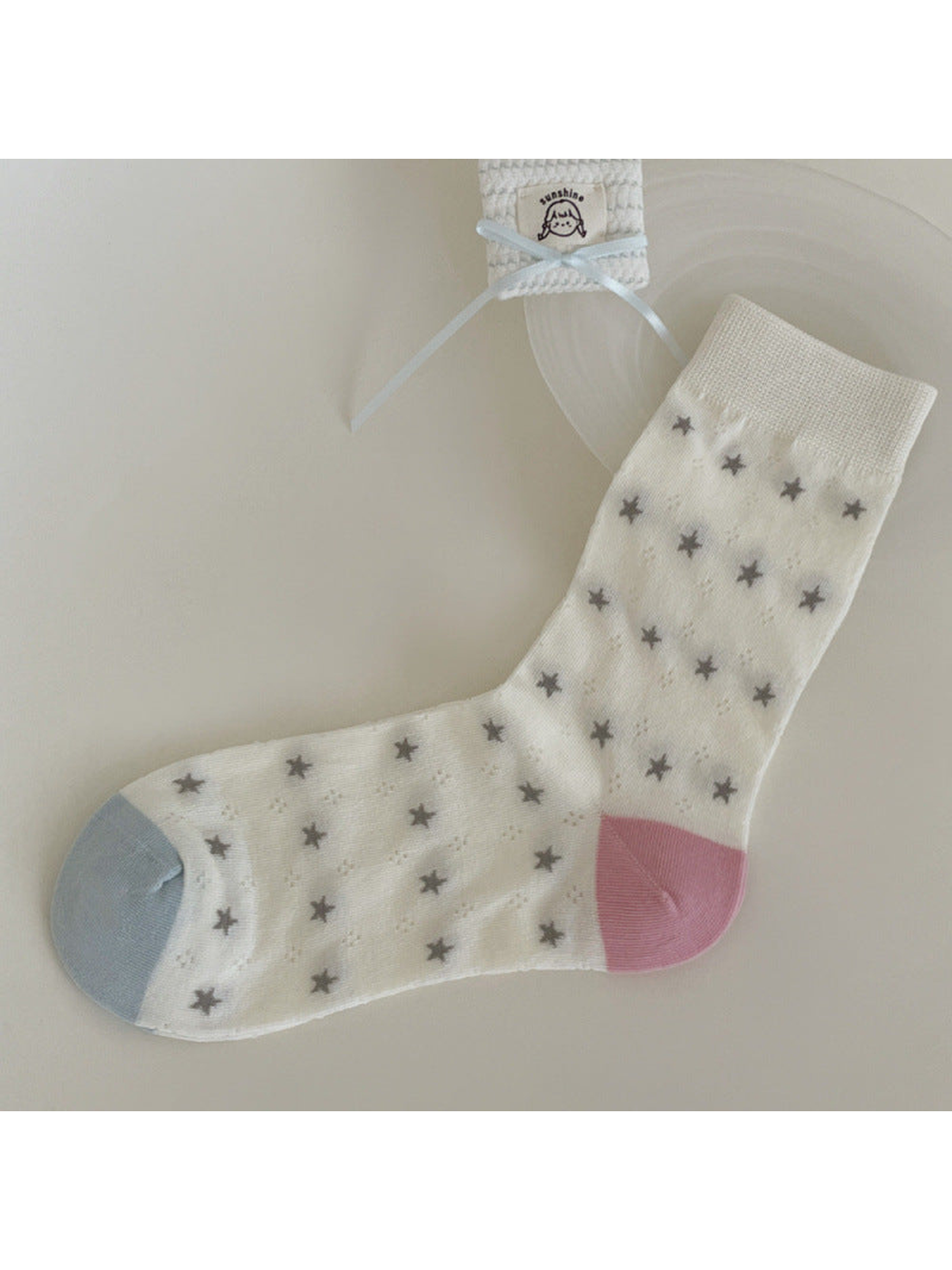 Ivory crew sock with gray stars, pale blue toe and pink heel