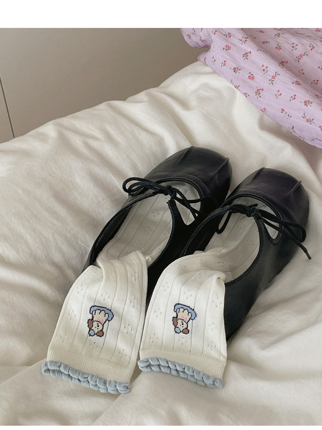 Pair of ivory dog motif crew socks styled with black lace-up flats
