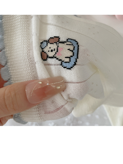 Close-up of a knit dog motif below a pale blue scalloped sock cuff