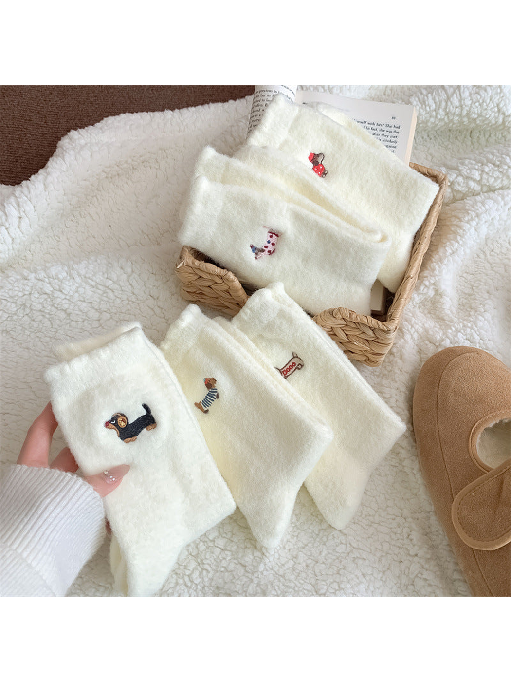 Folded ivory fuzzy socks with assorted embroidered dog motifs