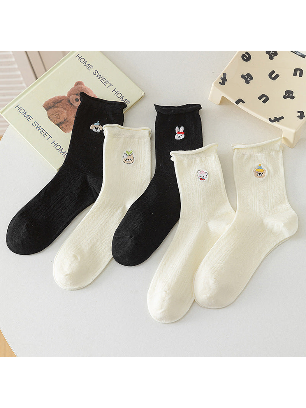 Black and ivory crew socks with embroidered character motifs arranged together