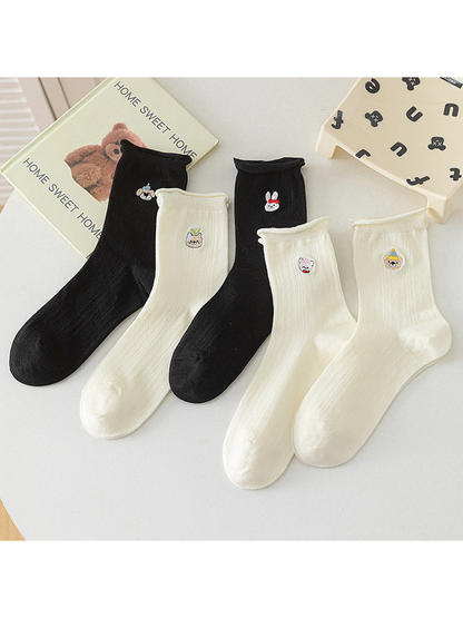Black and ivory crew socks with embroidered character motifs arranged together