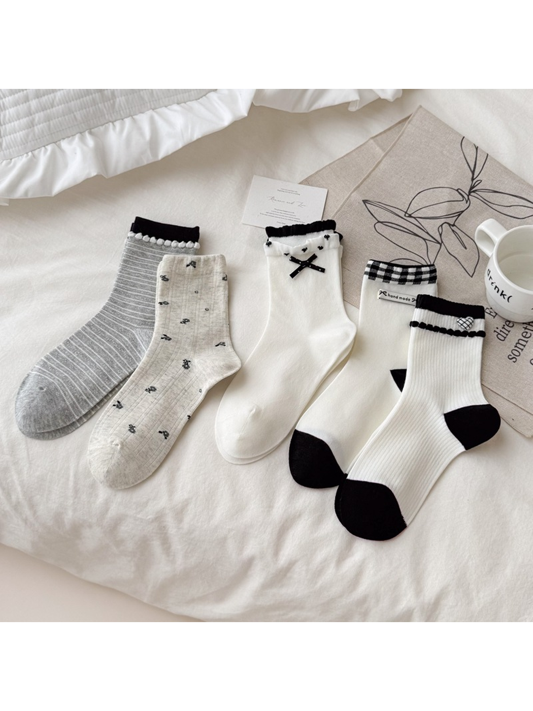 Five coordinating white, ivory, beige and gray crew sock styles arranged together