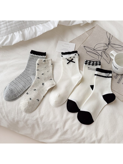 Five coordinating white, ivory, beige and gray crew sock styles arranged together