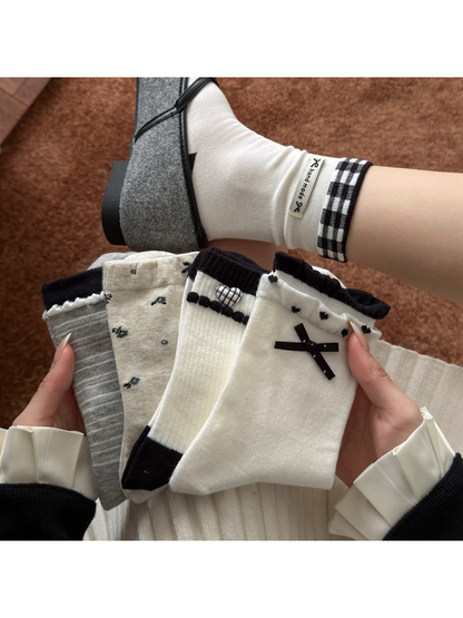 Five coordinating crew sock styles displayed by a seated model