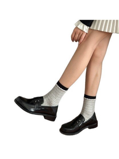 Gray finely striped crew socks styled with black loafers