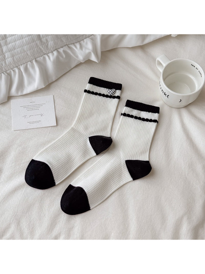 White ribbed crew socks with checked heart accents and black trim