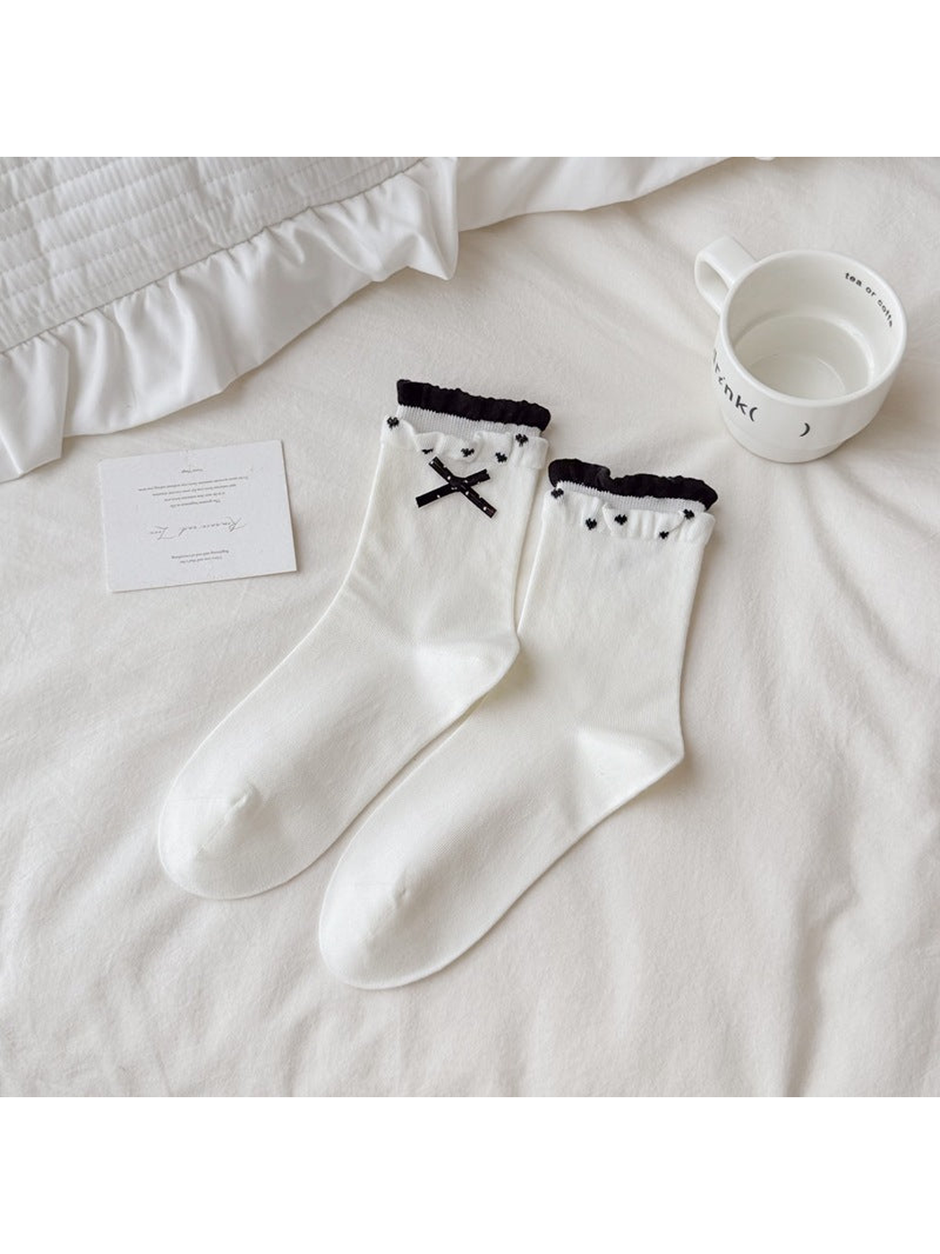 White crew socks with black bows, heart motifs and ruffled cuffs
