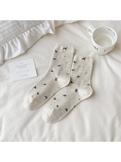 Beige crew socks with scattered black floral motifs