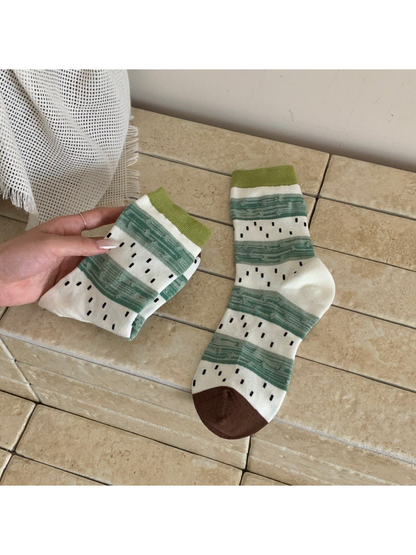 Green and white striped crew socks with black seed-like dashes