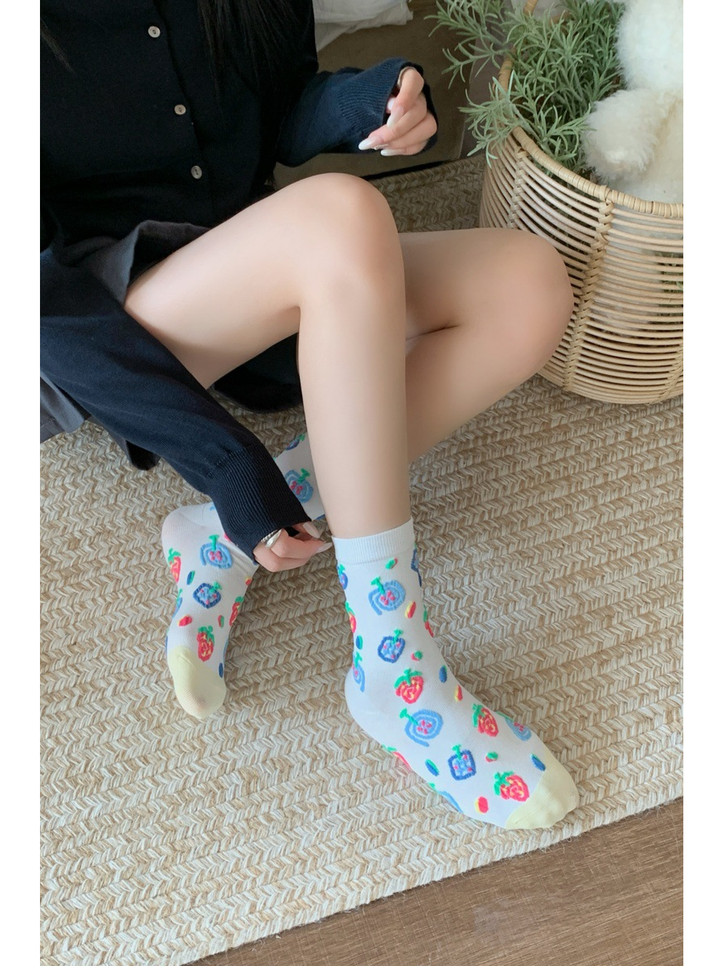 White fruit-pattern crew socks worn in a seated indoor setting
