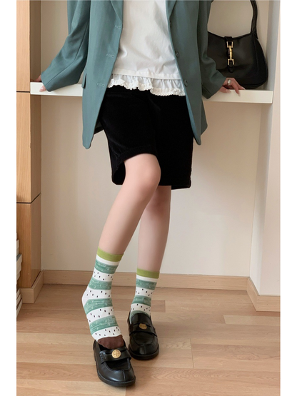 Green and white striped crew socks styled with black loafers