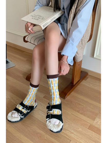 Raised blue and yellow dash crew socks styled with black sandals