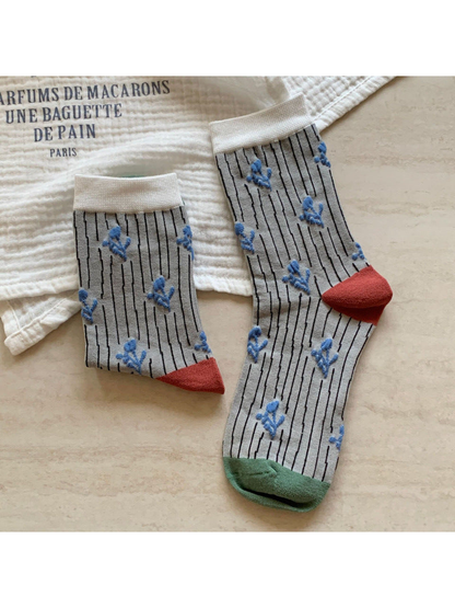 Light gray crew socks with black pinstripes and raised blue flowers