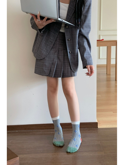 Light gray pinstriped floral crew socks worn with a skirt