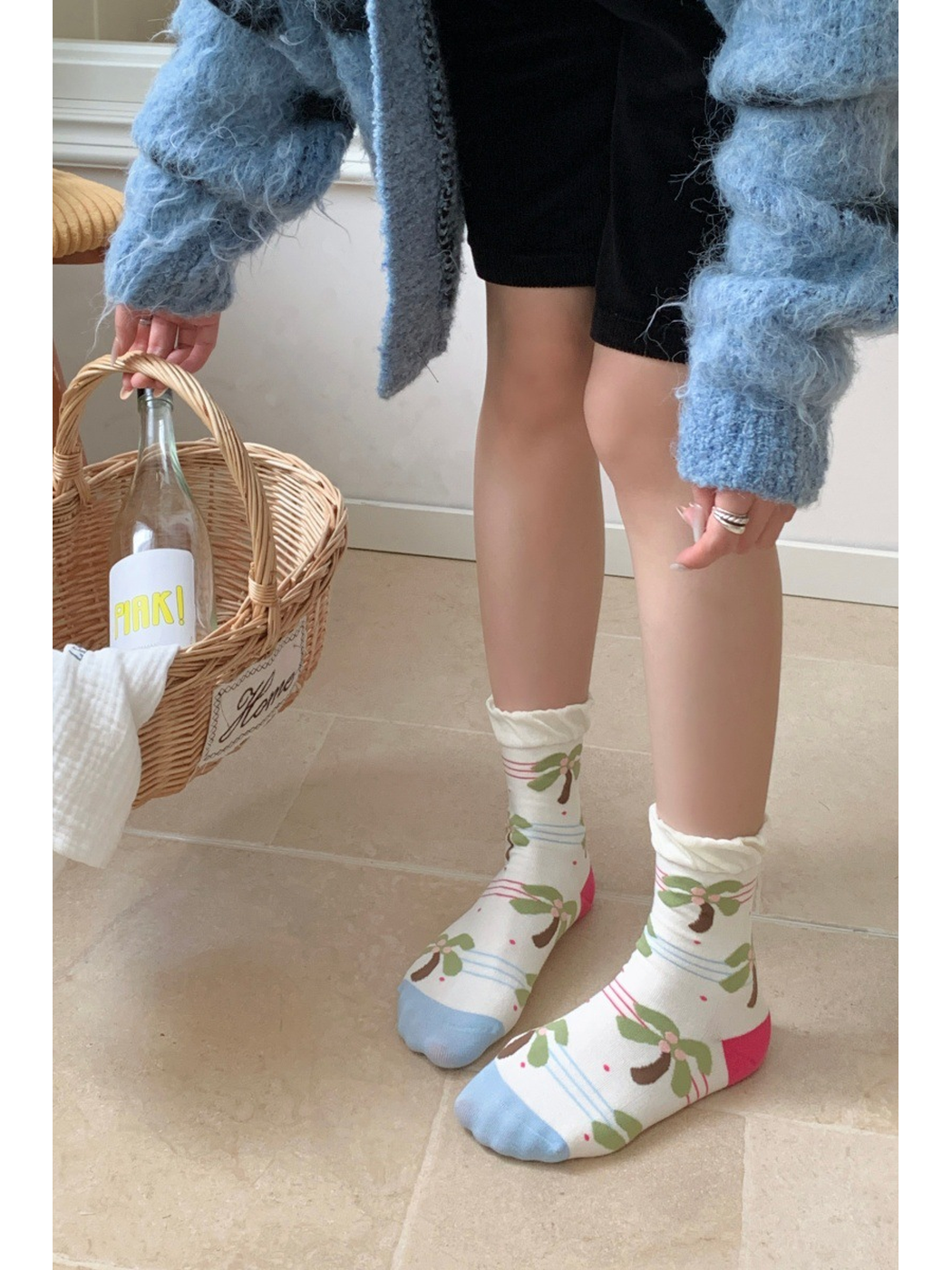 Ivory palm tree crew socks worn in a standing view